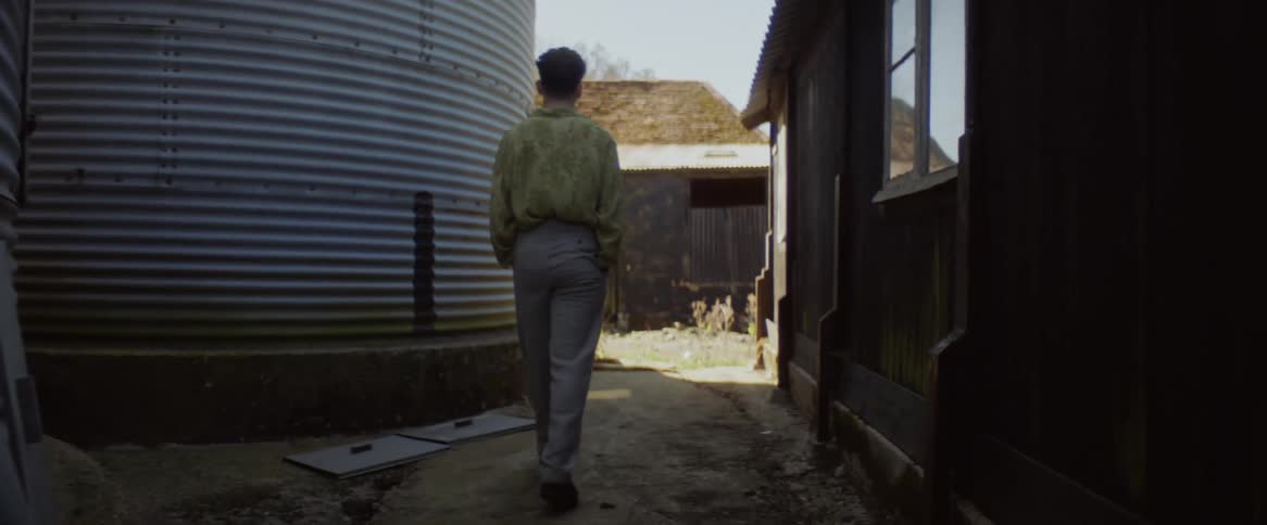 A man is walking past the silos