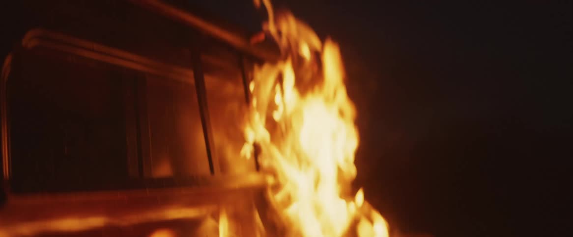 A wooden structure burns indoors