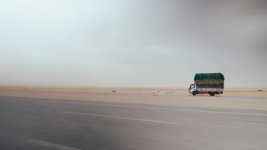 A truck is driving through a desert area in Saudi Arabia