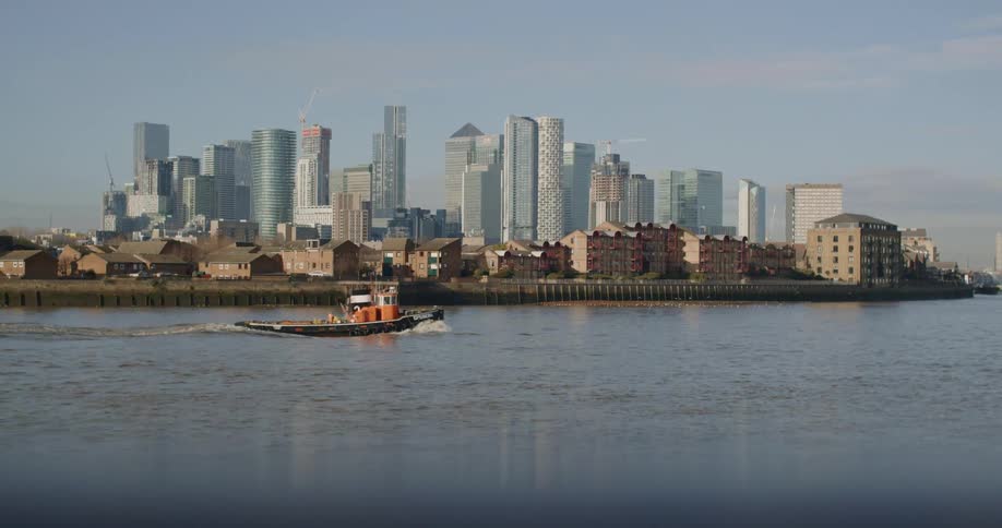 A small boat sails past a dense city