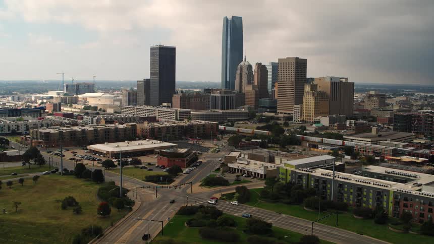 An aerial view of vehicles driving in a city with high rise office buildings