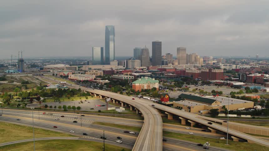 Traffic moves along highways near downtown on a foggy overcast day