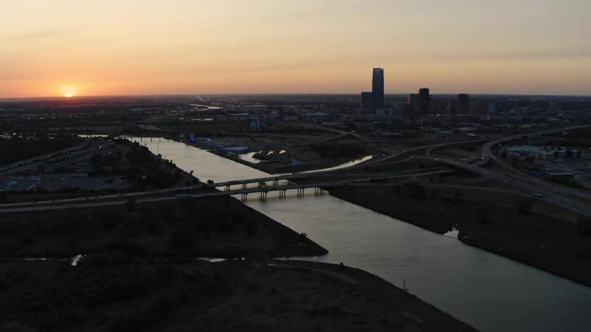 An aerial view of a city at dusk and a bridge going over a waterway