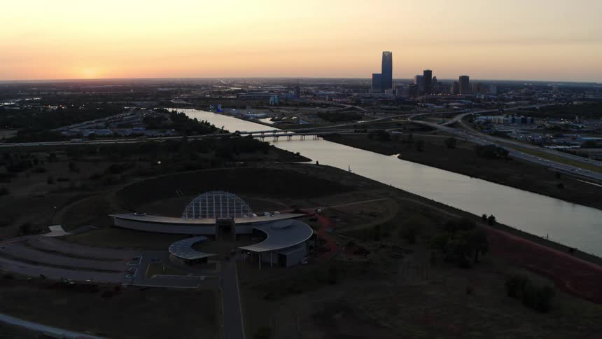 A river divides a large arena from downtown
