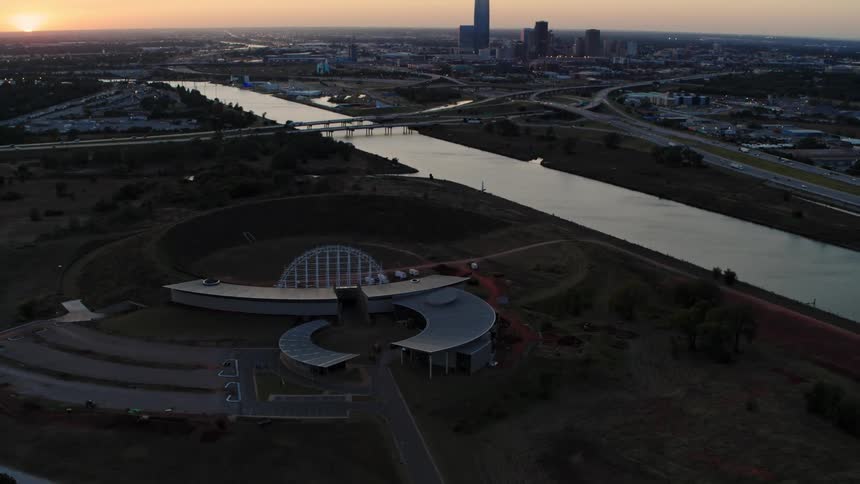 An aerial view of a building and a city skyline at dawn