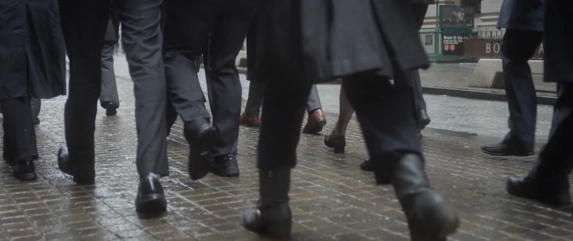 A group of men and woman walk down a wet stone path