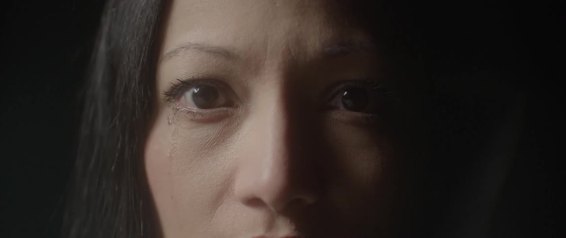 A woman is wide eyes and crying