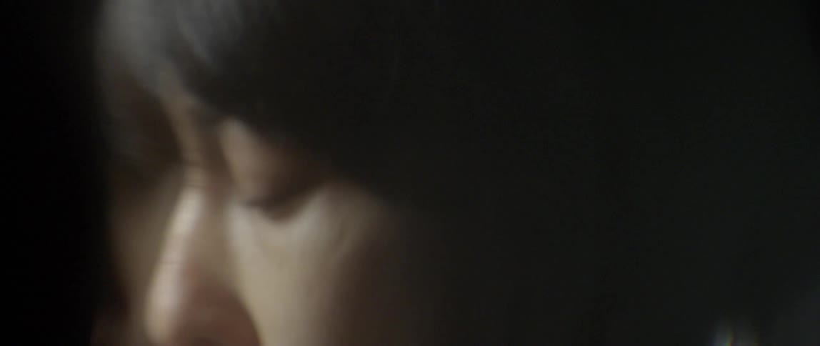 An asian person sits in thought