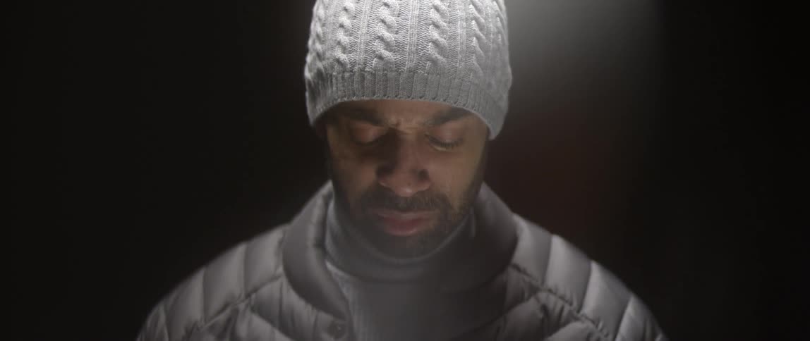 A man is looking down with his eyes closed