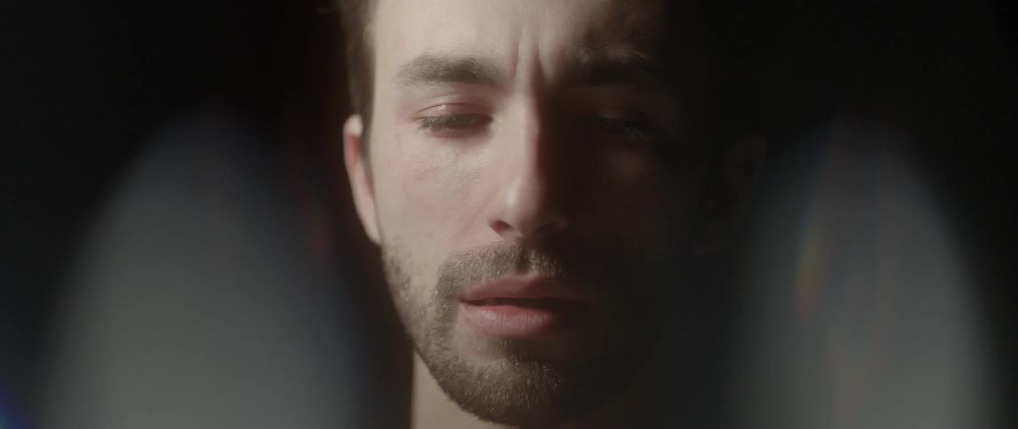 A man is looking down blinking