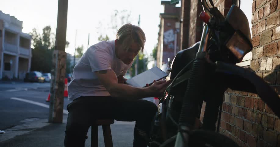 A man is checking over his motorcycle