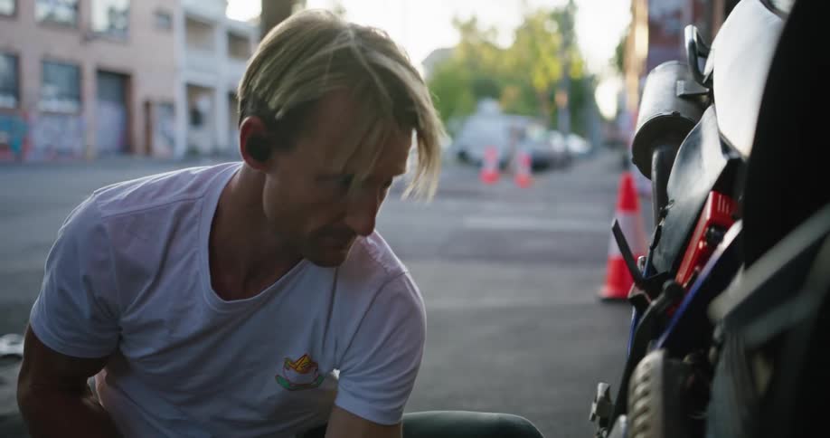 A man is checking out his motorcycle
