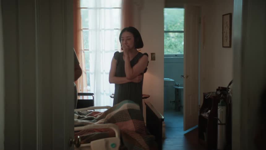 A asian woman worrying about someone on a bed