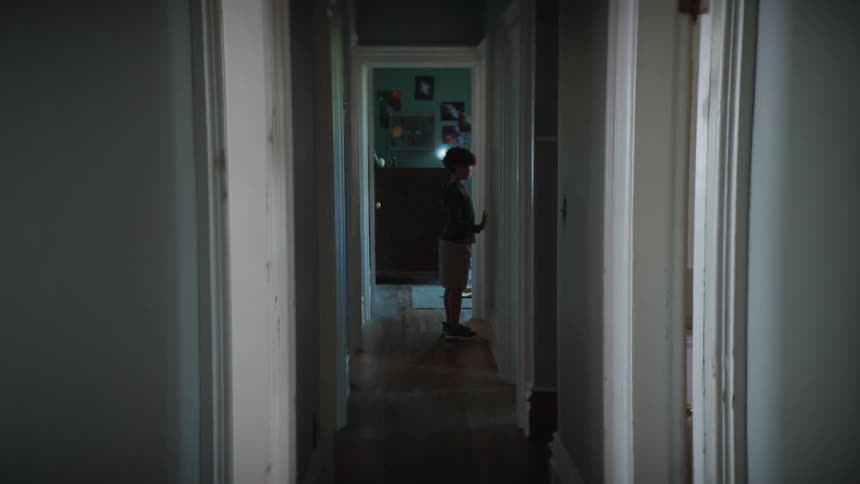 Boy with t shirt and shorts stands in the corridor in the building