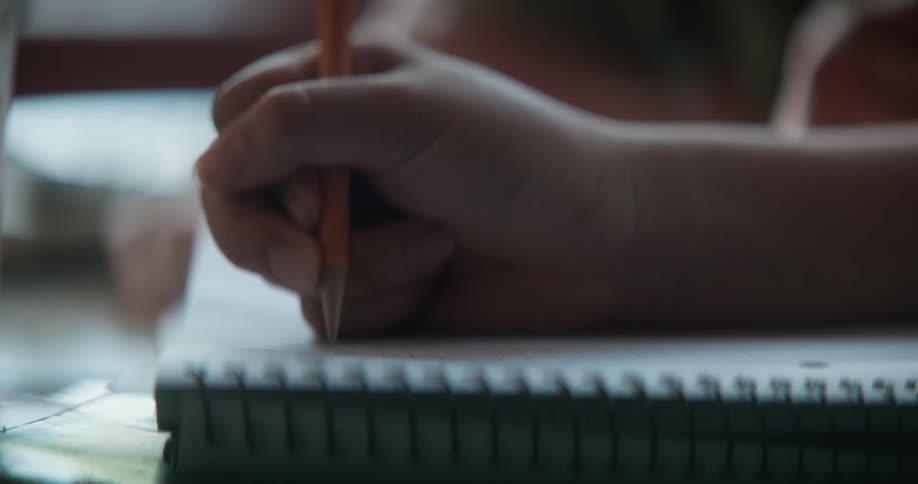 Girls hand writing down in notebook