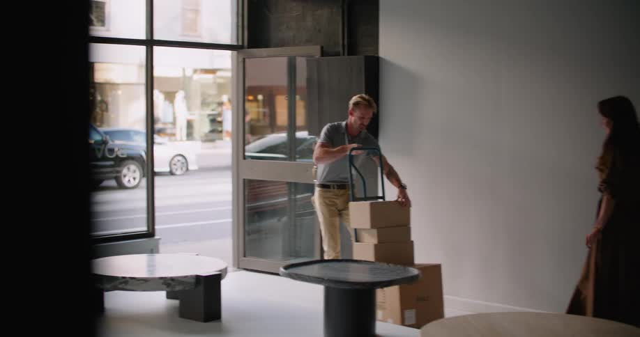 A delivery man wheels packages into a restaurant downtown