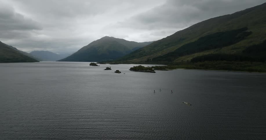 An aerial view of people paddle boarding and boating on a lake