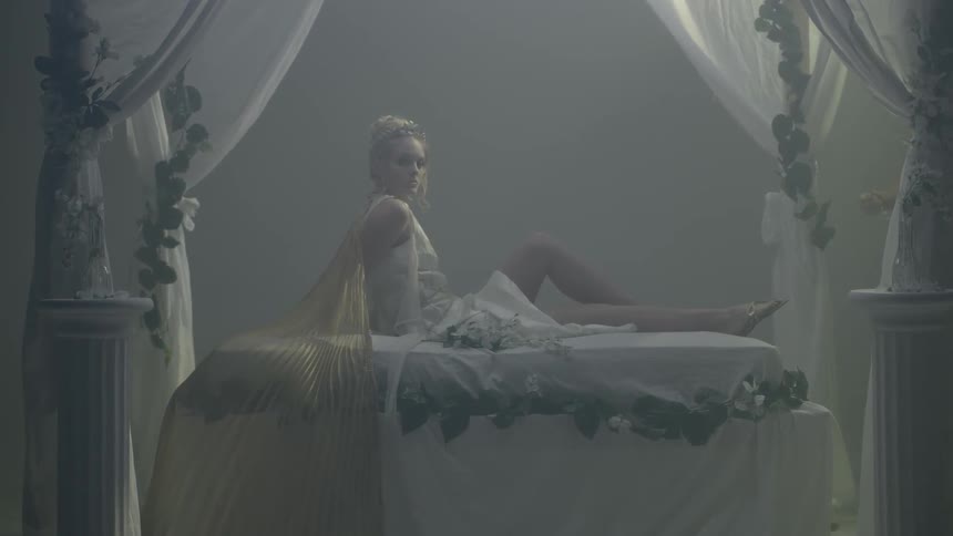Dressed up woman posing on a bed