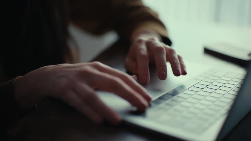 A woman uses the trackpad on her laptop