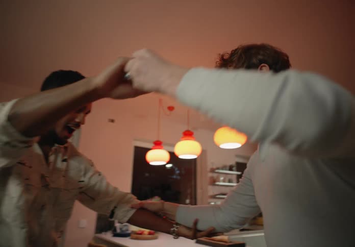 Two men are dancing at home
