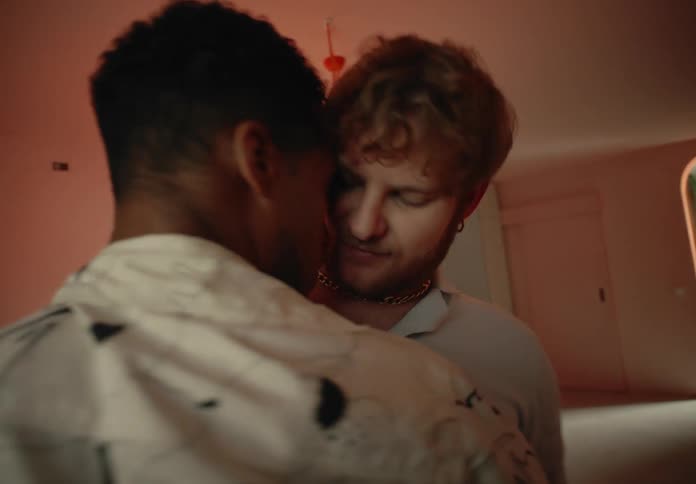 Two men dance and make out in a room