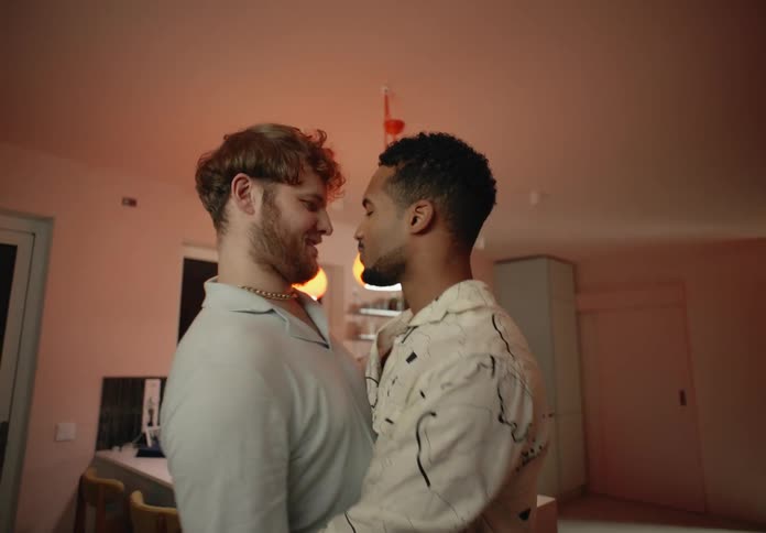 Two men dance intimately in a room