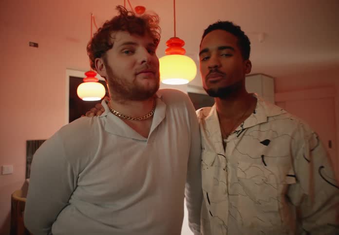 A couple embrace while posing in their kitchen