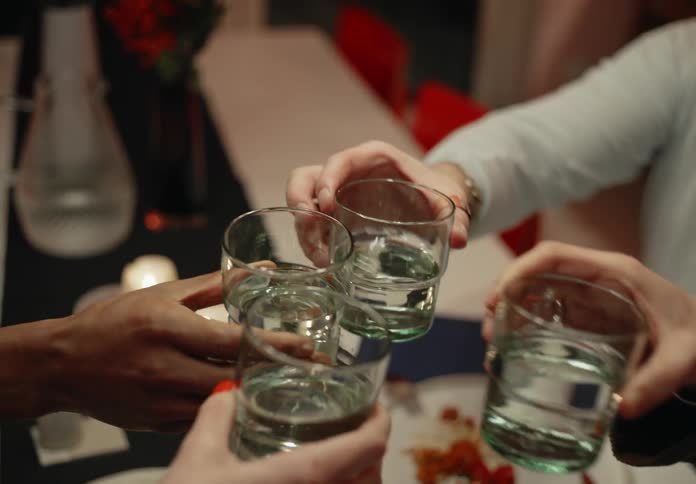 A group of friends hold up drinking glasses for a toast