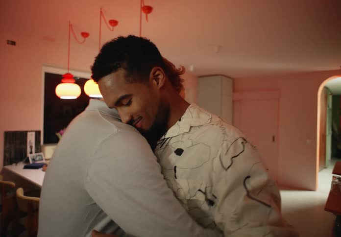 A couple embrace while slow dancing in their kitchen