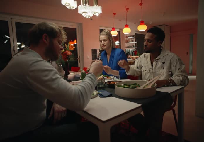 Four young people enjoying food and talking at the dining room table