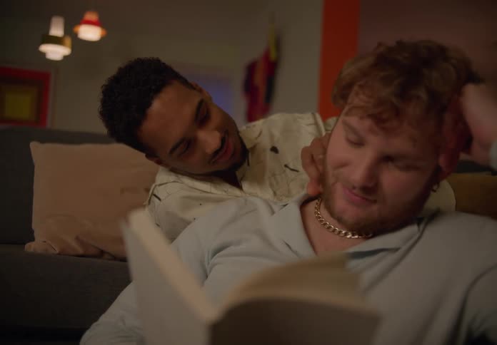 A black man playing with a white man trying to read