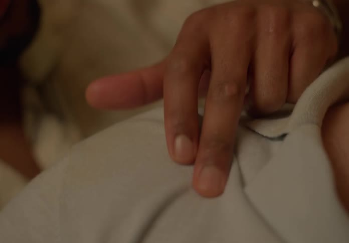 A man runs his fingers along his partners shoulder and neck