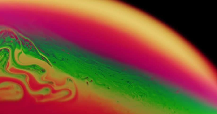 Fluorescent stripes move and blend across the surface on an orb