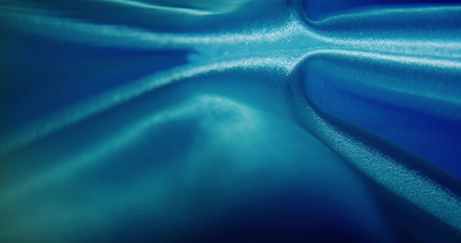 Blue translucent objects separate as they float in rippling water