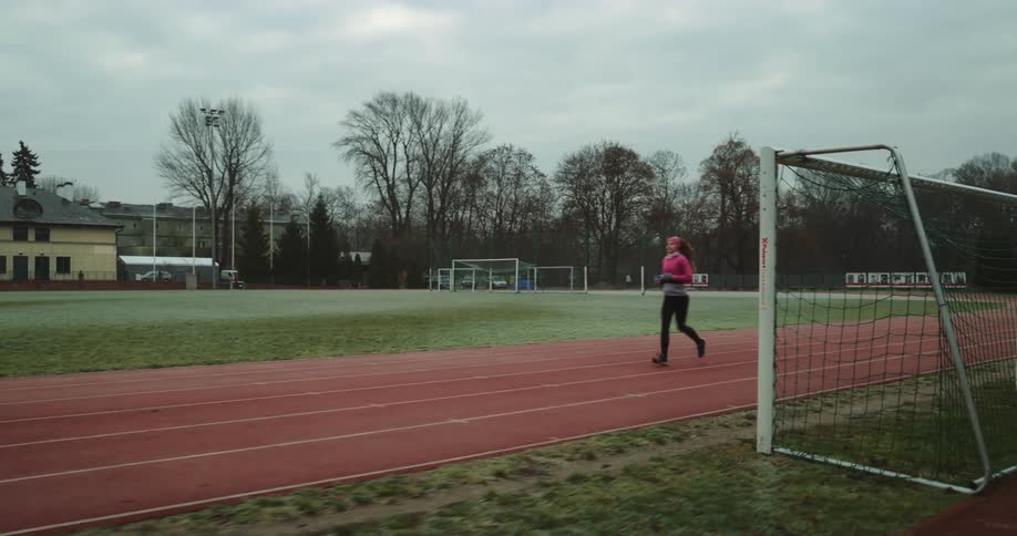 Woman jogging on a track and field