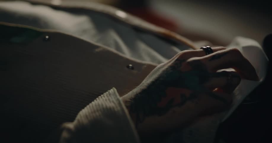 A man taps his fingers on his waistline while lying down