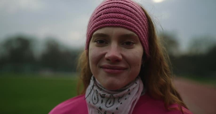 A woman breathing on a track and field trying not to cry