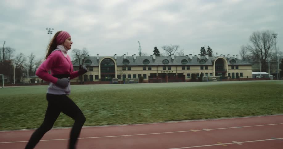 Female jogger running on track speeds up after another jogger passes her