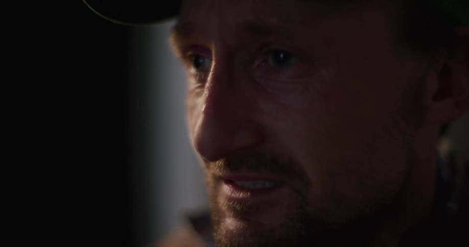 A man talks as he wipes tears from his eyes