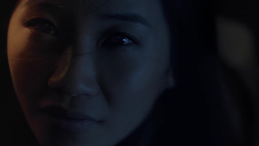 An asian woman is shown focusing her gaze in one direction in a thoughtful way