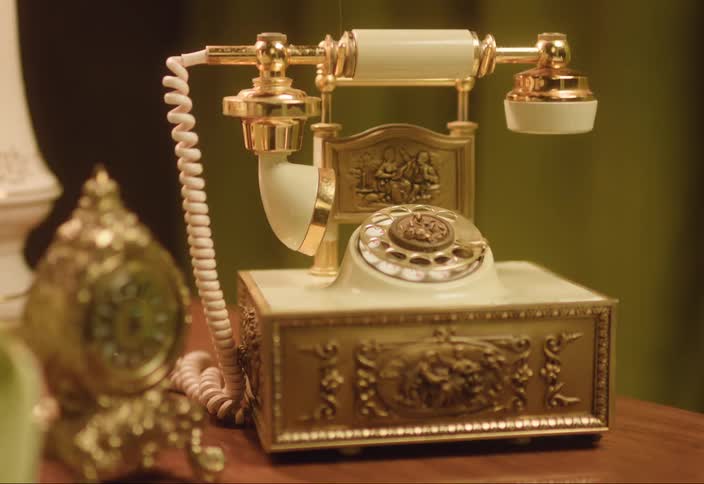 An old style rotary telephone sitting on a table bounces as it rings