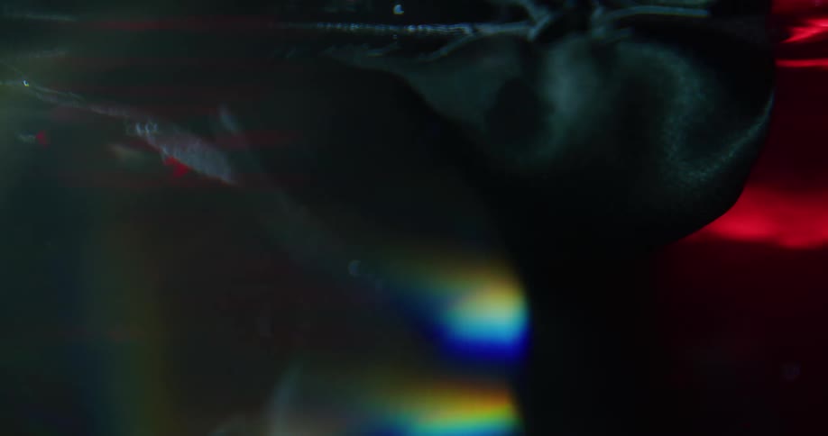 Clothes moves through water in wash as light creates prismatic effect