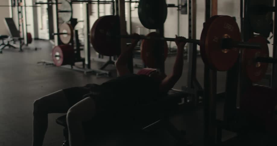 A man is bench pressing in the gym