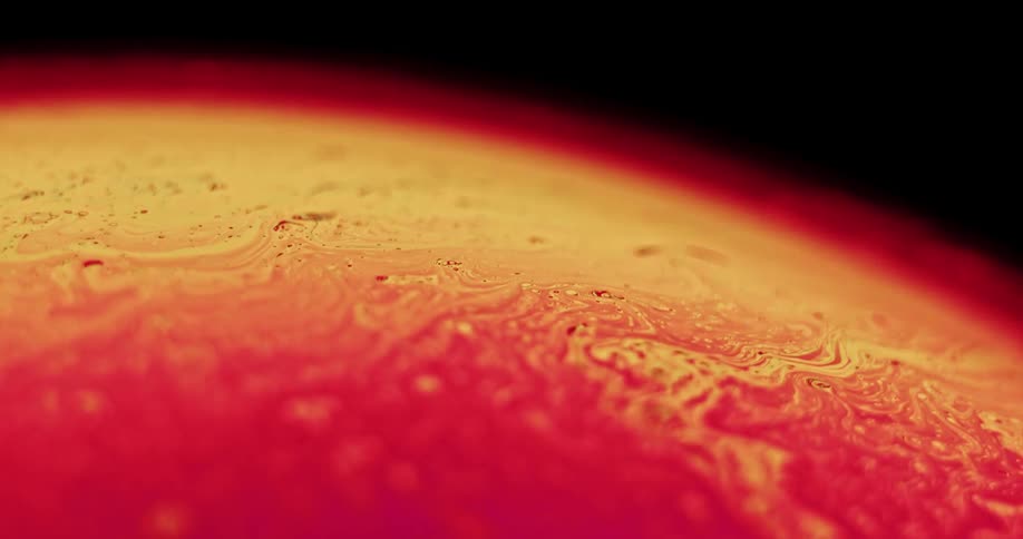Close up of abstract red and yellow colors flowing on sphere