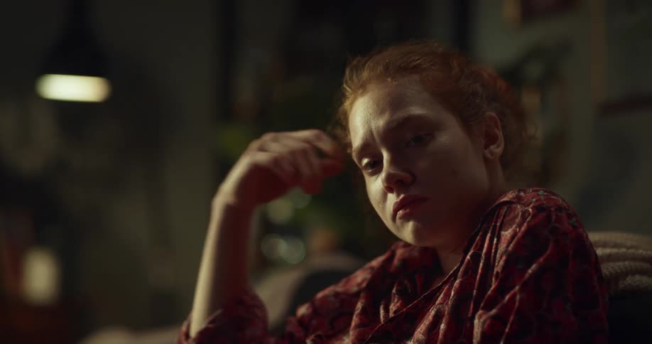 Redhead sitting thinking turns and smiles