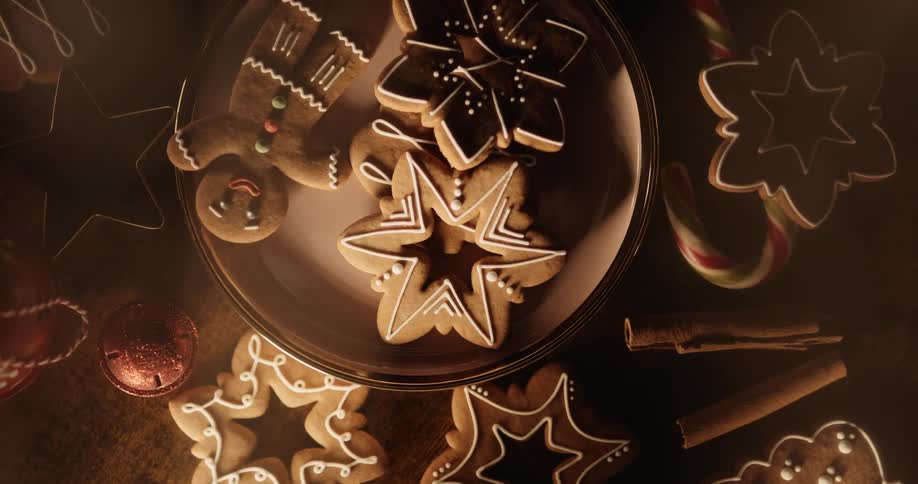 Holiday cookies of gingerbread men and stars are on a plate and on the table