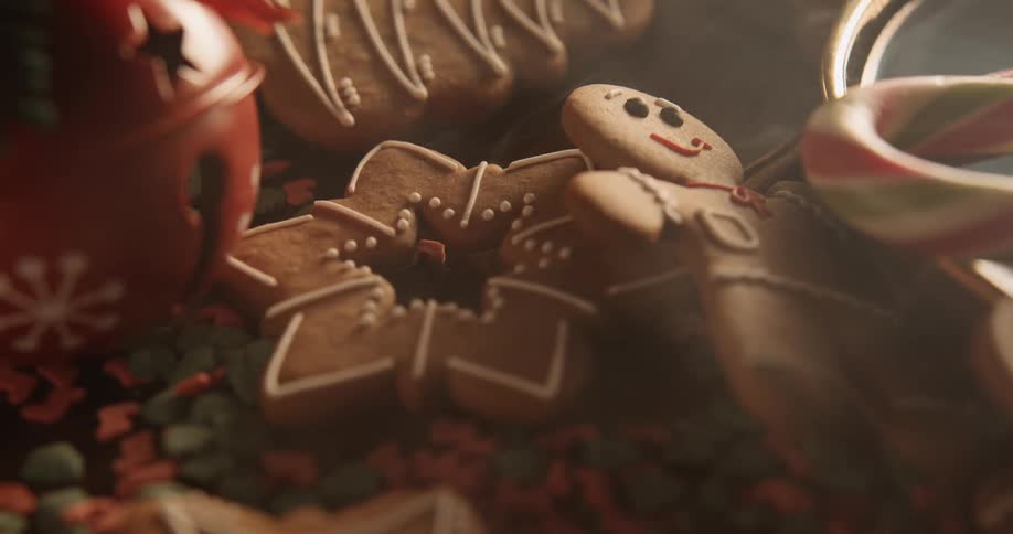 Holiday gingerbread cookies are on the table with candy canes as wisps of smoke float over the table