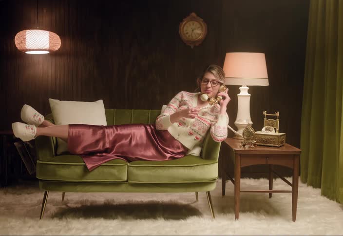 A woman is talking on a rotary phone