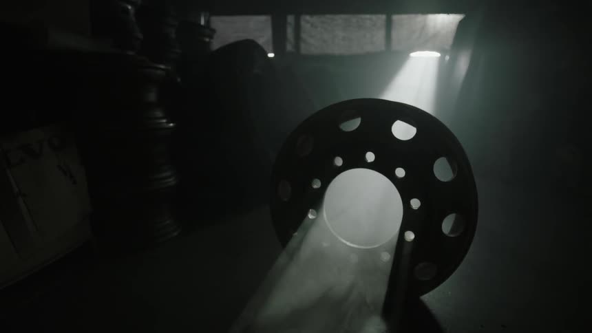 A wheel is laying in a dark garage