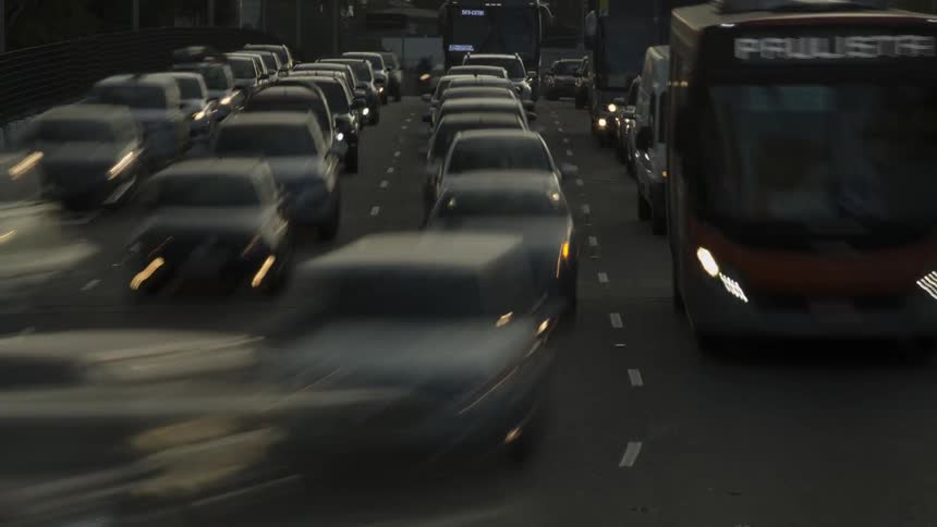 Cars and buses crawl through heavy traffic on highway